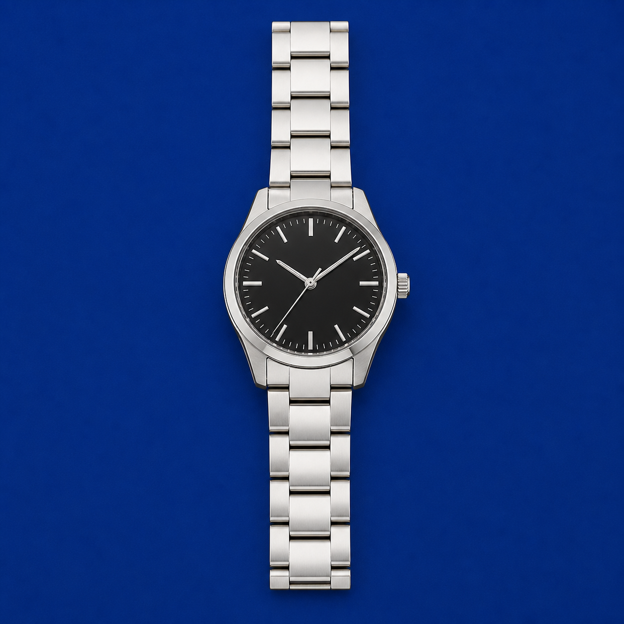 Original demonstration photograph of a reflective wristwatch laid flat on a deep blue backdrop